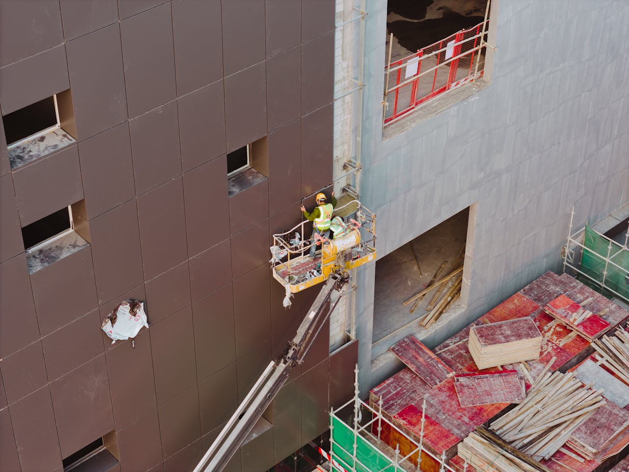 Aerial view of construction worker on crane fixing building facade in Huaian, Jiangsu, China.